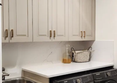 a laundry room with cabinets that were finished and painted by FHG Contracting